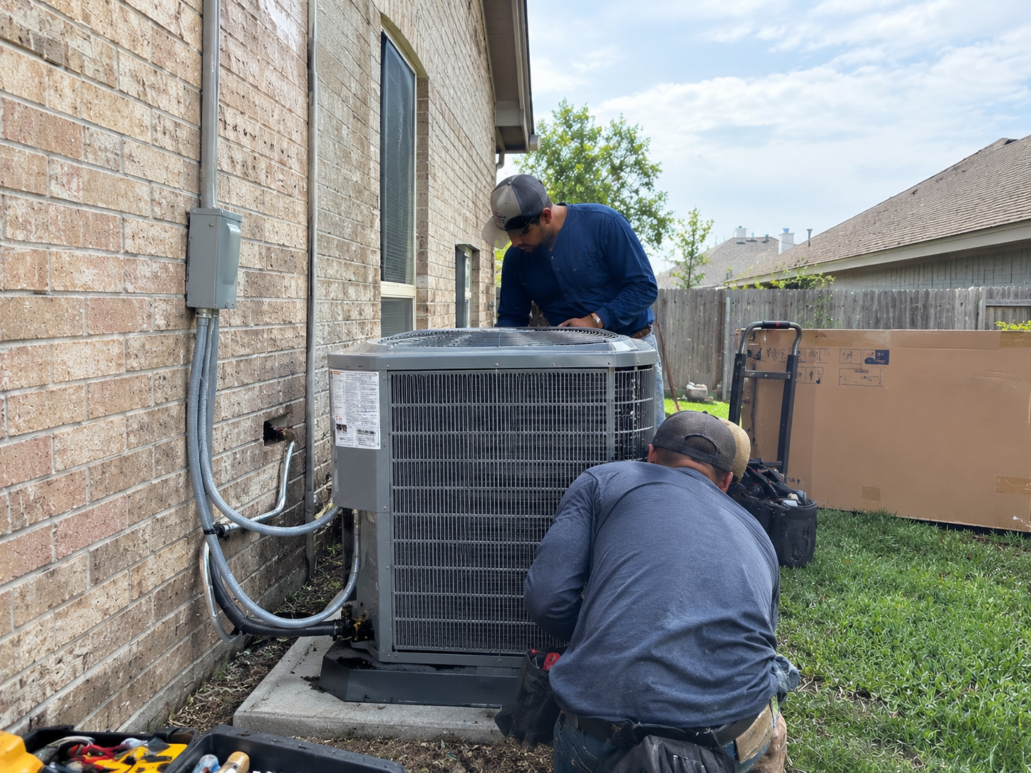 HVAC technicians installing outdoor condenser unit in Rosenberg TX